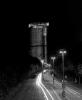Post Tower at night, Bonn, july 2004. Rolleiflex 2.8 C, Ilford HP5. I chose an 8 sec exposure to emphasise the headlight trails from the passing cars. Amusingly, this was one of those rare situations in which I would've appreciated dense traffic simply for sheer spectacle, but considering it was 1:00 AM and the fact that Bonn is just a glorified cowtown with no appreciable nightlife, it was sparse at best. Oh well. The Rheinaue recreational park borders to the right, certainly not a place to wander around in at the time this pic was taken...